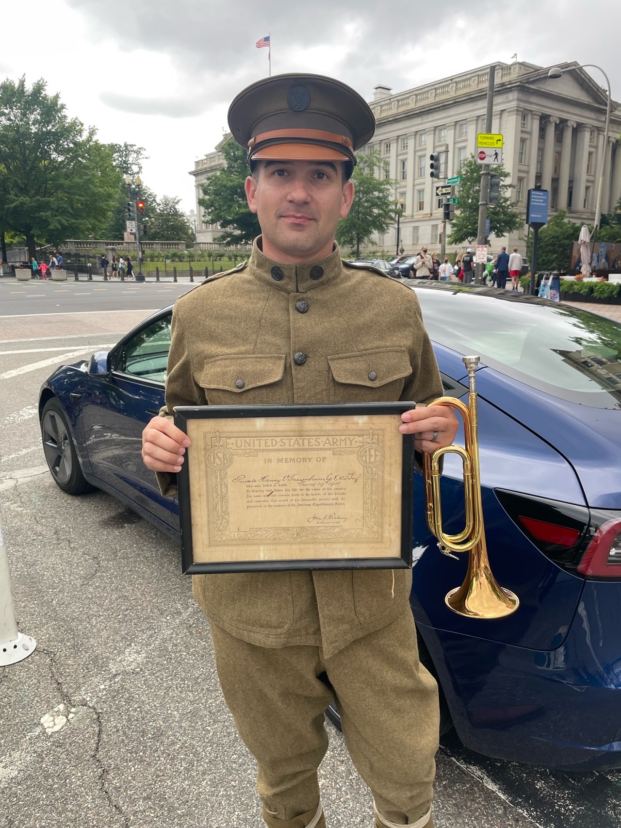 Taps Bugler Kevin Paul holding Pvt. Henry V. Traynham's certificate at the National World War I Memorial in Washington, DC.