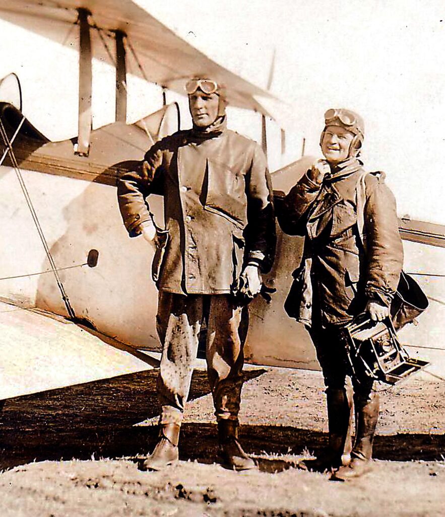 Two aviators next to a Curtiss Jenny aircraft