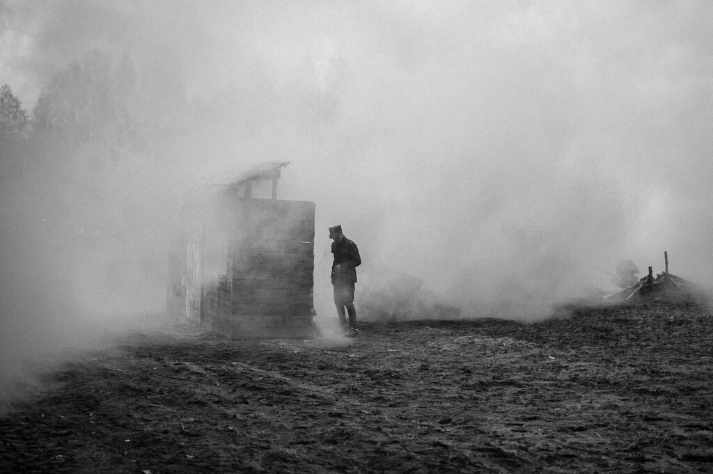 a black and white image of a soldier in a bleak environment