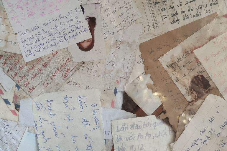 A flat lay of overlapping vintage handwritten letters, notes, and postcards, evoking the kind of paper keepsakes families keep tucked away for generations.