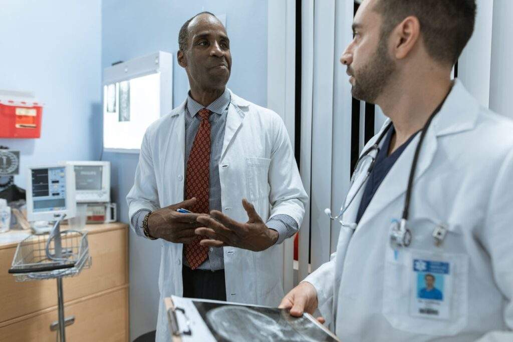 : two doctors in lab coats discussing an X-ray